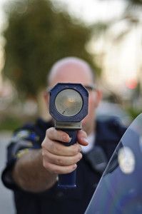 cop pointing radar gun - Are Fees From Minor Violations Bleeding Lower Income Citizens Dry?