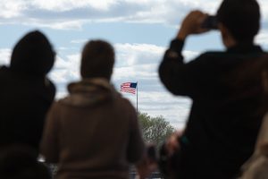 Silhouettes of travelers looking at the flag of the United States of America | How Dangerous are Immigrants